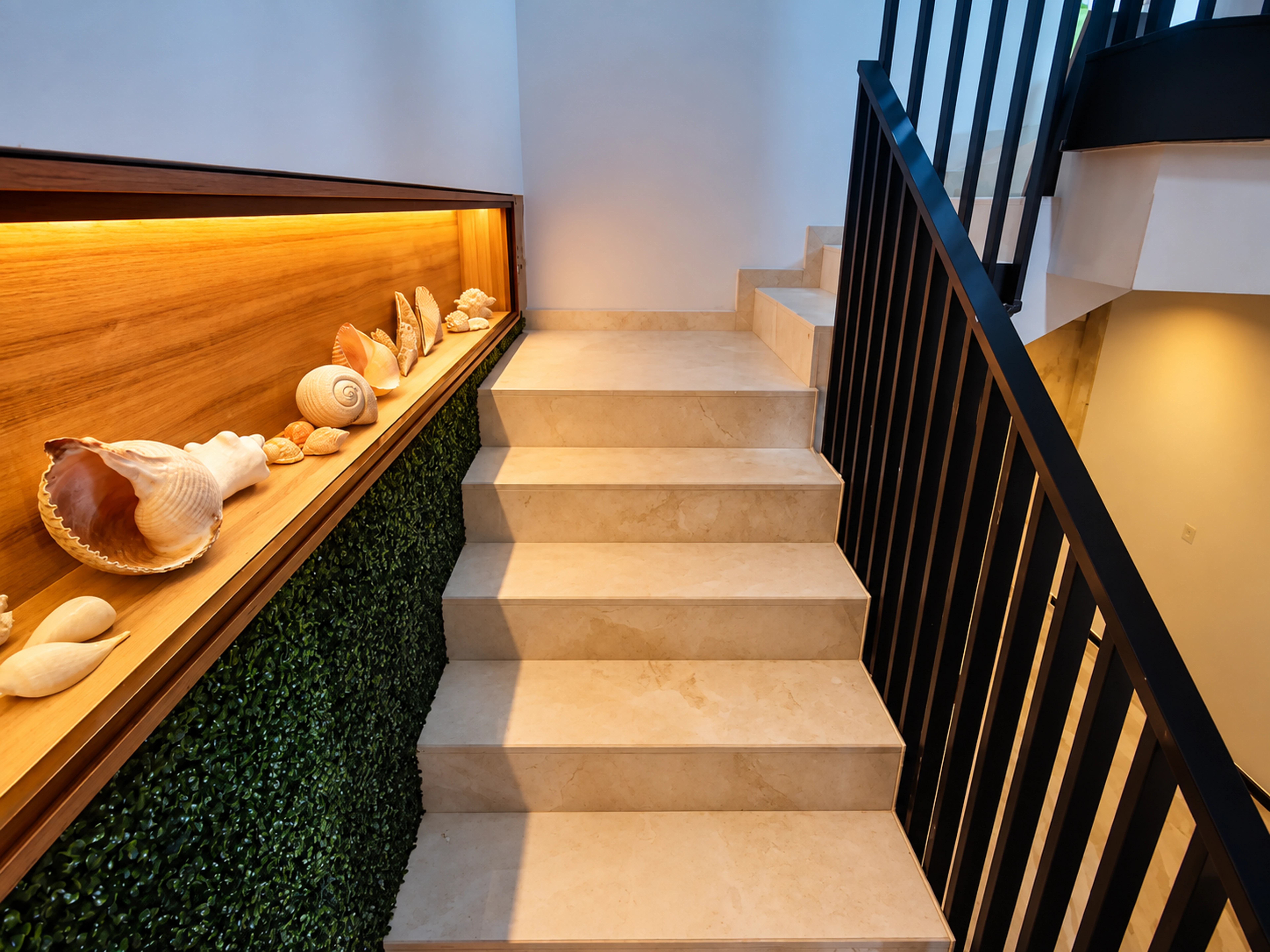 Interior stair with a black balustrade and illuminated display niche