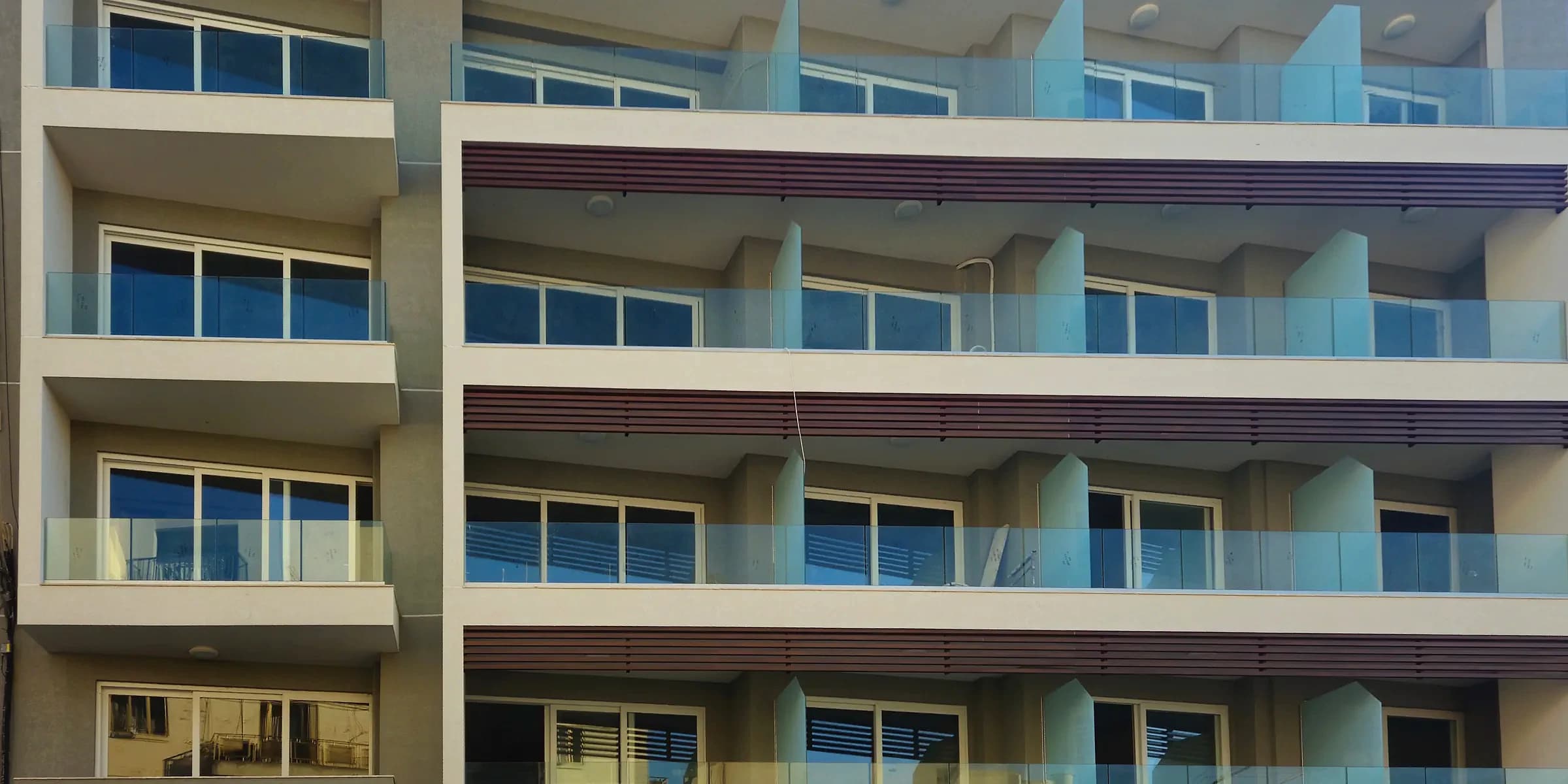 Seafront apartment block with glass balustrades and horizontal facade details