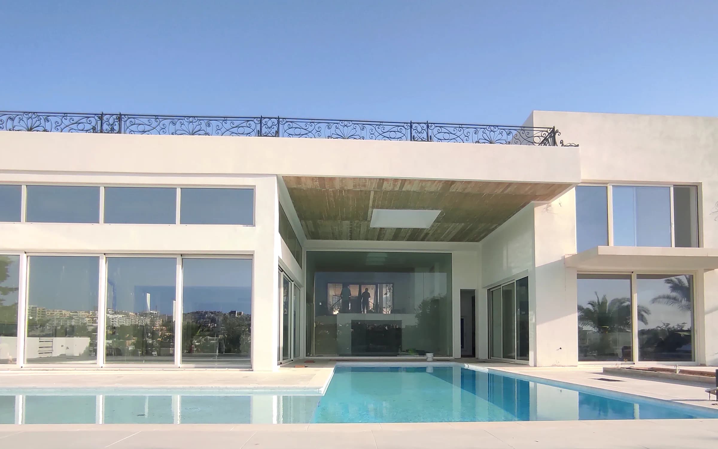 Modern villa with a full glazed elevation reflected in a pool