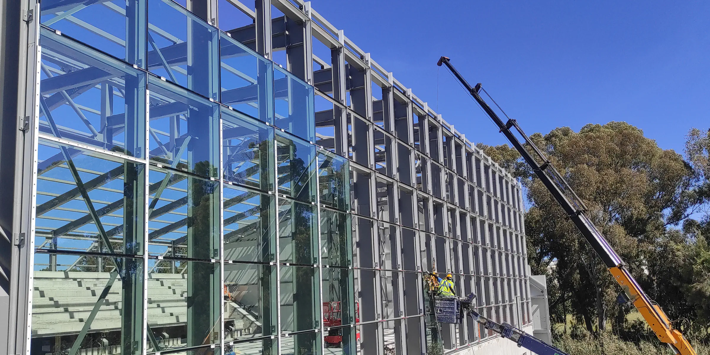 Large curtain wall installation with a mobile crane and operatives on site